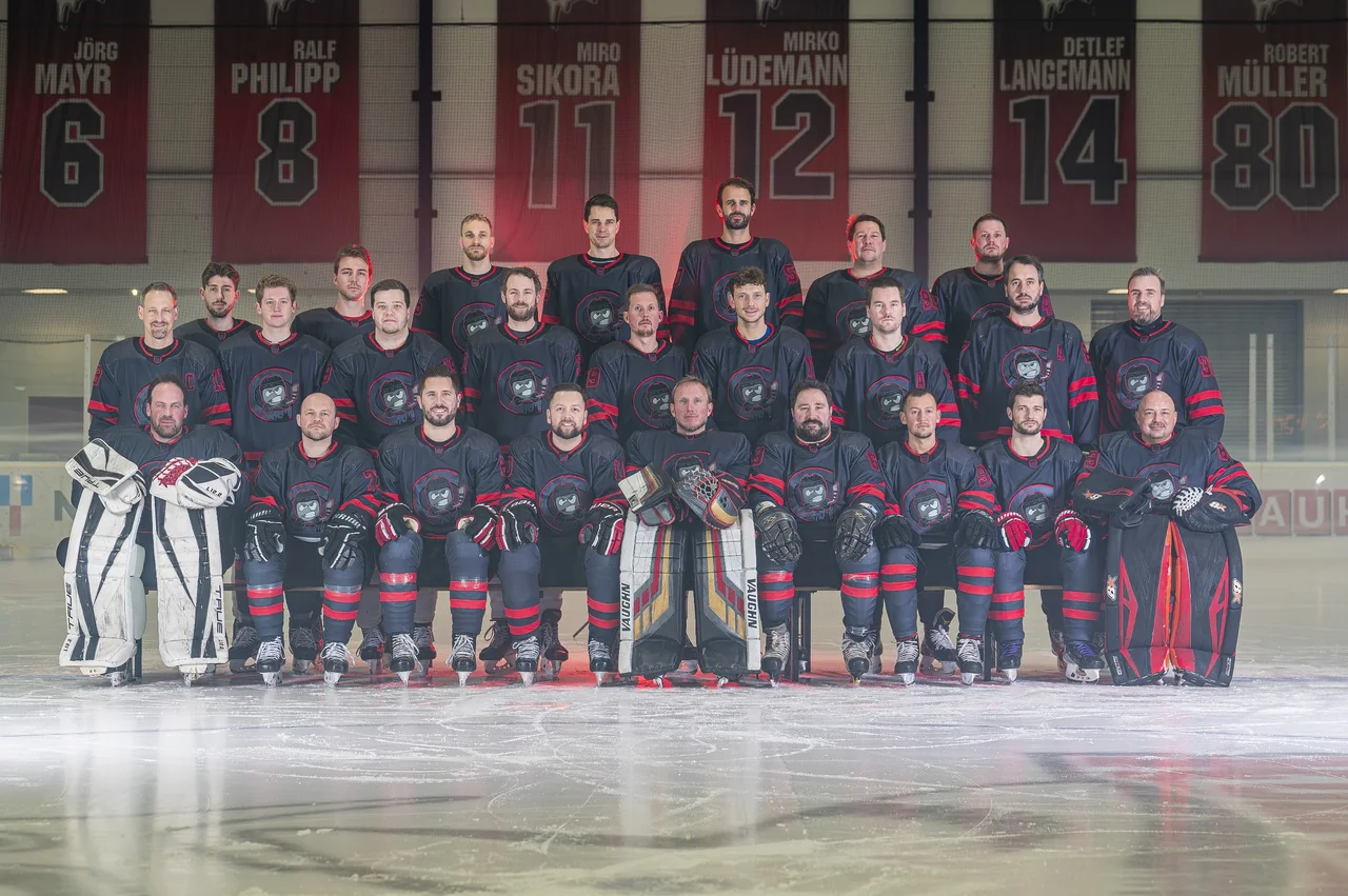 Mannschaftsfoto eines Eishockeyteams auf dem Eis vor Trikotbannern
