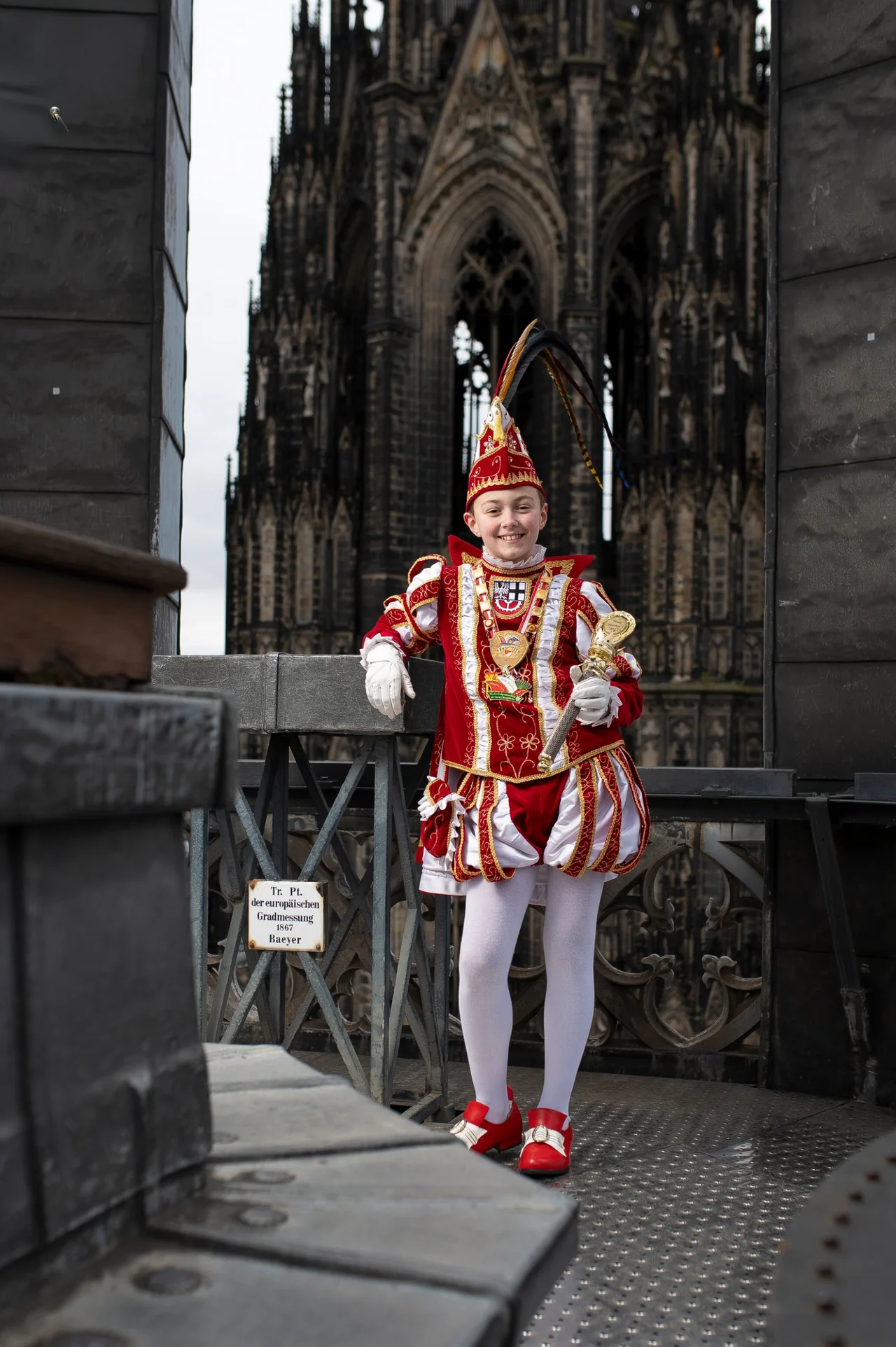Kinderprinz im Ornat mit Zepter auf einer Aussichtsplattform vor dem Kölner Dom