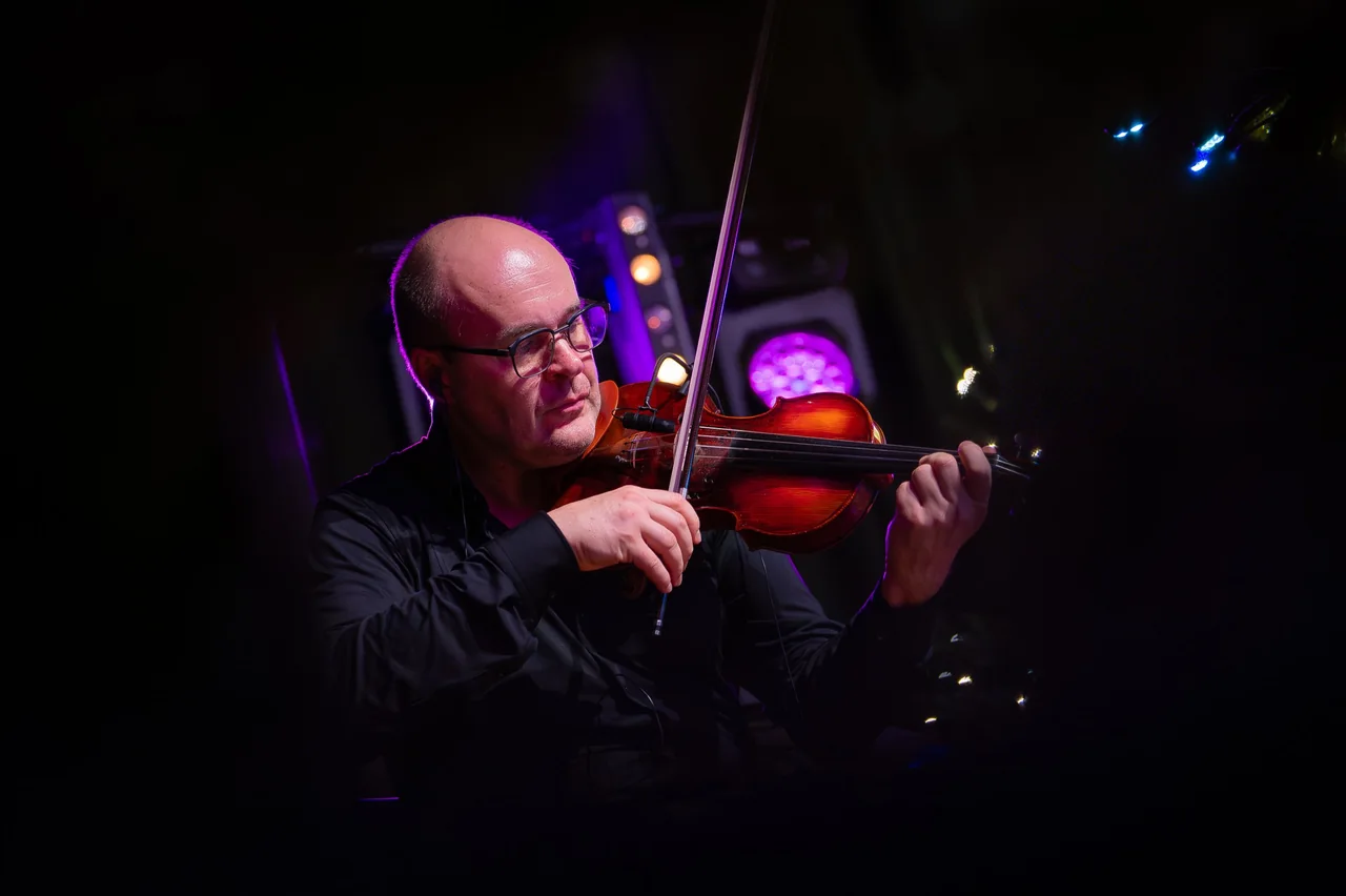 Geiger im violetten Bühnenlicht, ganz auf sein Spiel konzentriert